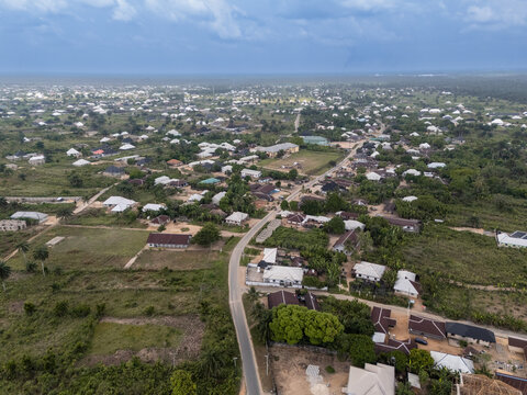 Aerial view of buildings nestled amongst the lush greenery, with a winding road cutting through the landscape, Egbema, Rivers, Nigeria.