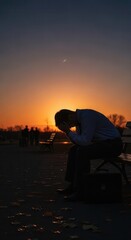 Fototapeta premium Silhouetted businessman slumps onto park bench in despair against vibrant sunset