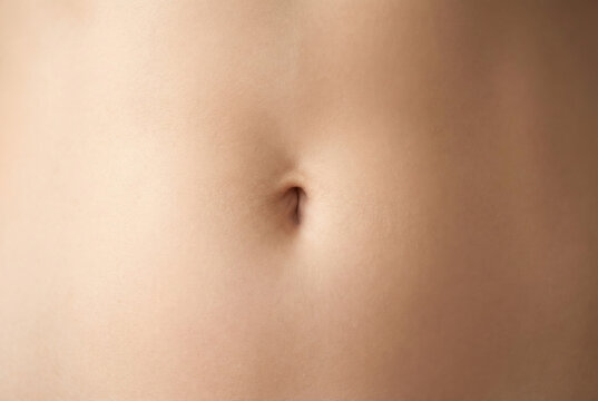 Close-up of a human belly button, showing the navel in detail on smooth skin