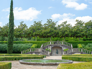 Fototapeta premium A beautiful French garden features a circular fountain in the middle