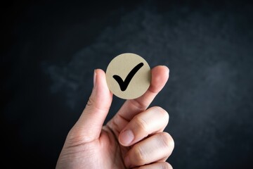 A hand holding a small paper with a checkmark on it, symbolizing confirmation or approval.