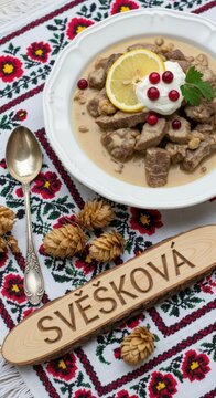 Traditional Czech Sv&iacute;čkov&aacute; na Smetaně (Beef Sirloin in Cream Sauce) with Carved Linden Sign and Moravian Folk Embroidery