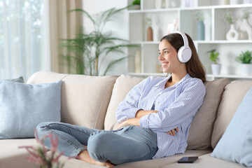 Happy woman in blue wearing headphone listening audio content