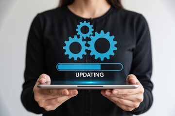 A woman in a black shirt holding a tablet with an updating progress bar and gears on the screen