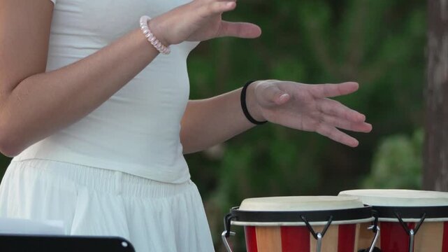Woman Playing Percussion Bongo Drums Outdoors, a Musical Performance