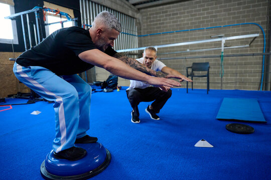 Men training padel fitness on bosu ball