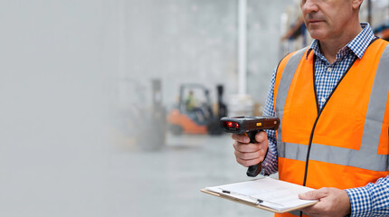 Man in orange safety vest using barcode scanner in warehouse