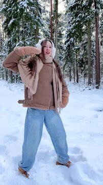 Teenage girl dancing freely in a snowy forest, enjoying nature and winter atmosphere. Joyful outdoor activity, freedom, mindfulness and connection with nature.