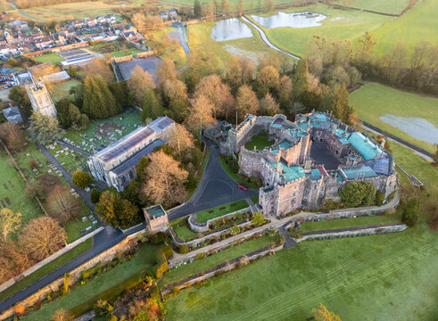 Aerial view of a medieval castle with its imposing stone walls and the adjacent church, bathed in the soft glow of a winter afternoon, Berkeley, England, United Kingdom.