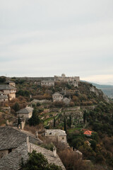 Obraz premium Wide view of Pocitelj Fortress with stone houses and terraced gardens on the hillside above the Neretva River, showing preserved medieval village architecture in Bosnia and Herzegovina.