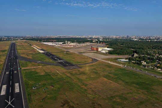 Aerial view of Tegel Airport's runway cutting through a landscape where the horizon meets the cityscape, Berlin, Berlin, Germany.