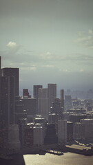 Obraz premium Tall buildings rise against a moody sky, creating a dramatic urban landscape. The sunlight glimmers off the water, highlighting the busy city below, evoking a sense of wonder.
