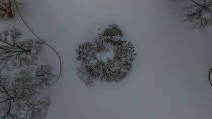 Aerial view of a snow-covered park blanketed in white, with trees and benches dusted in a fresh layer of powder, creating a stark winter scene, Boston, Massachusetts, United States.