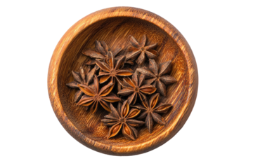 Overhead shot of star anise spices nestled within a small, wooden bowl against a black backdrop