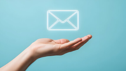 Hand presenting glowing email icon on blue background for communication