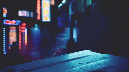 Neon signs glow brightly as they reflect off wet pavement in a lively urban alley. The atmosphere buzzes with energy from nearby shops and late night diners. © icetray