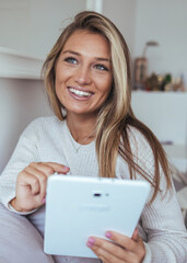 Friendly Woman Smiling While Using Tablet At Home In A Cozy Indoor Setting, Warm Morning Light