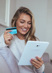 Joyful Woman Shopping Online with Credit Card and Tablet at Home for Easy Payments