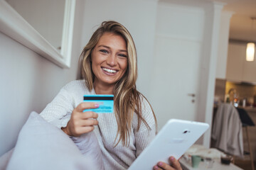 Happy Woman Relaxing On Couch With Credit Card And Tablet In Bright Home Interior