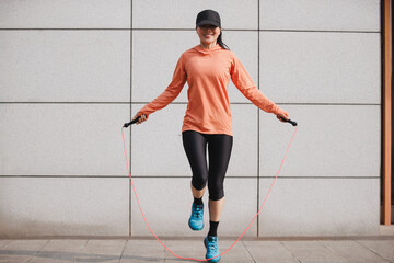 Fitness woman rope skipping in the city