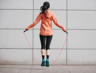 Fitness woman rope skipping in the city