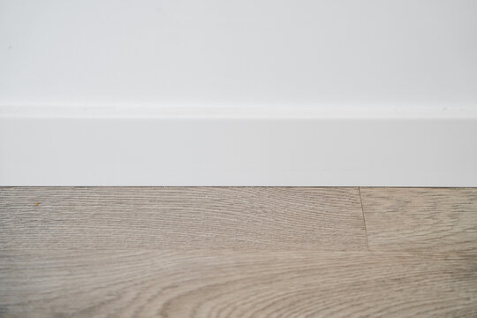 Minimal white interior wall with wooden floor and baseboard, clean empty room background with copy space for design and real estate
