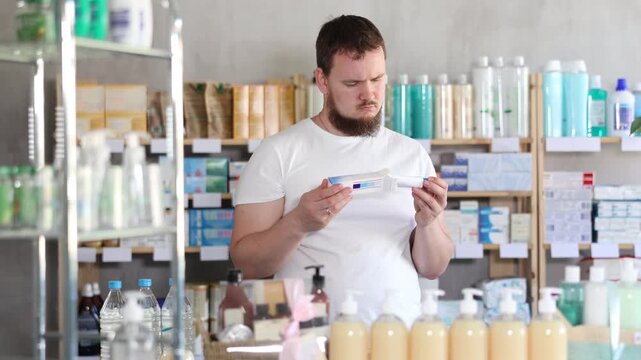 Male buyer buys medicinal ointment at a pharmacy. High quality 4k footage