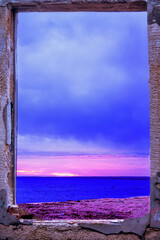 The sea before sunrise. View from the door of a house destroyed by the sea. The concept of a temporary truce