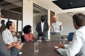 Businesswoman presenting to diverse team during business meeting