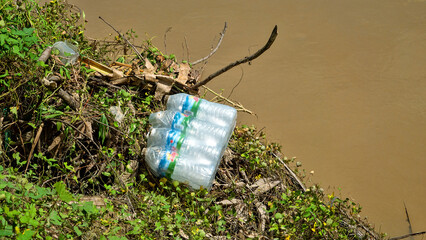 Anthropogenic debris, including plastic bottles, on the banks of the Padan River after a flood, Borneo Island. Notorious plastic pollution has reached virgin rainforests