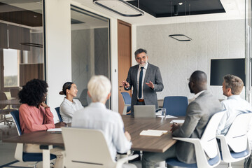 Fototapeta premium Mature businessman manager leading diverse team meeting