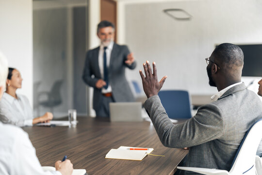 Business team collaborating during meeting, man asking question