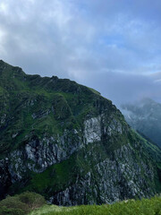 Obraz premium Mountain landscape with green hills and clouds in the sky during daylight hours