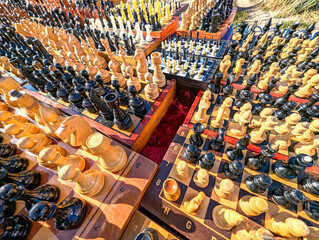 A multitude of wooden chess sets, displayed side by side like a majestic army. A phalanx ready to march into terrifying battle. Wide-angle perspective shot of strategic games intellectual challenges.