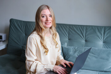 Modern lifestyle portrait of woman working remotely on laptop at home with natural light and relaxed atmosphere