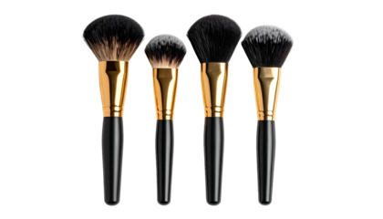 Four makeup brushes with black handles and gold ferrules, against a black backdrop