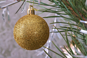 Golden Christmas ball as a Christmas tree decoration, close-up