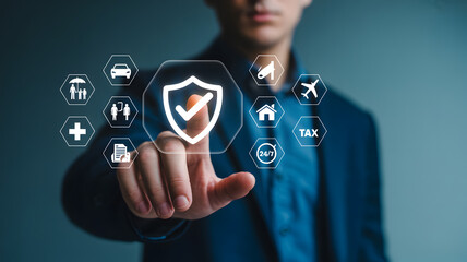 Businessman touching virtual shield icon with checkmark surrounded by insurance symbols on screen transparent background