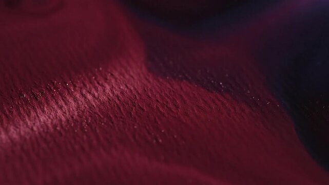 Abstract close up of deep red fluid forming dripping shape