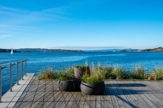 Oslo Norway deck boardwalk on waterfront with planters facing sea and sky for leisure in modern coastal setting with clean space summer