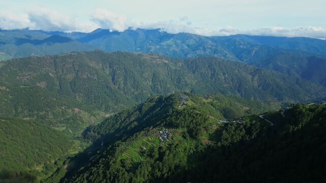 Slow tilting down aerial over the deep green ridges and forested peaks of Atok, Benguet, showcasing the vast, undeveloped mountain landscape.