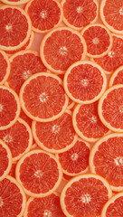 Refreshing and vibrant arrangement of pink grapefruit slices. Perfect for food and beverage backgrounds or designs with a fresh twist.