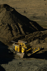 Dump Truck Unloading Gravel on Rural Construction Site in Dry Hilly Landscape