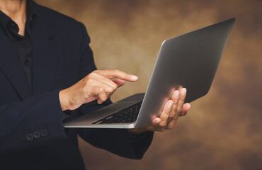 Businessman using laptop computer with one hand in professional setting