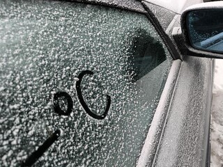 A frozen car window and minus degrees Celsius written with a finger