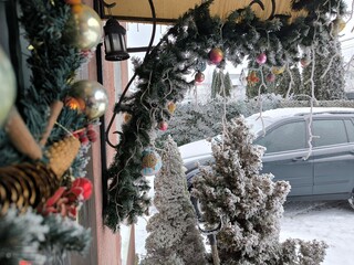 Beautifully decorated Christmas porch and a snow-covered car