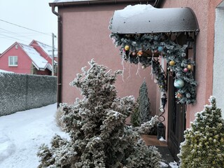 The porch of the house is beautifully decorated with Christmas tree decorations