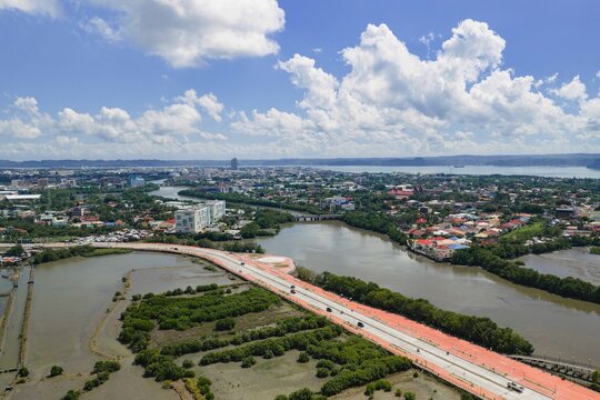 Aerial view of the city's vibrant waterways snaking through the urban landscape, a modern bridge contrasting with the natural beauty of Iloilo City, Western Visayas, Philippines.