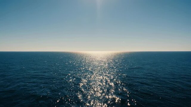 Breathtaking view of the ocean at sunset, showcasing a calming horizon under a clear blue sky. gentle waves ripple on the surface, reflecting sunlight in a pathway of light, creating a peaceful and tr