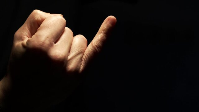 A small finger bends against a black background.
Finger joint.
Broken finger and pain from the injury.